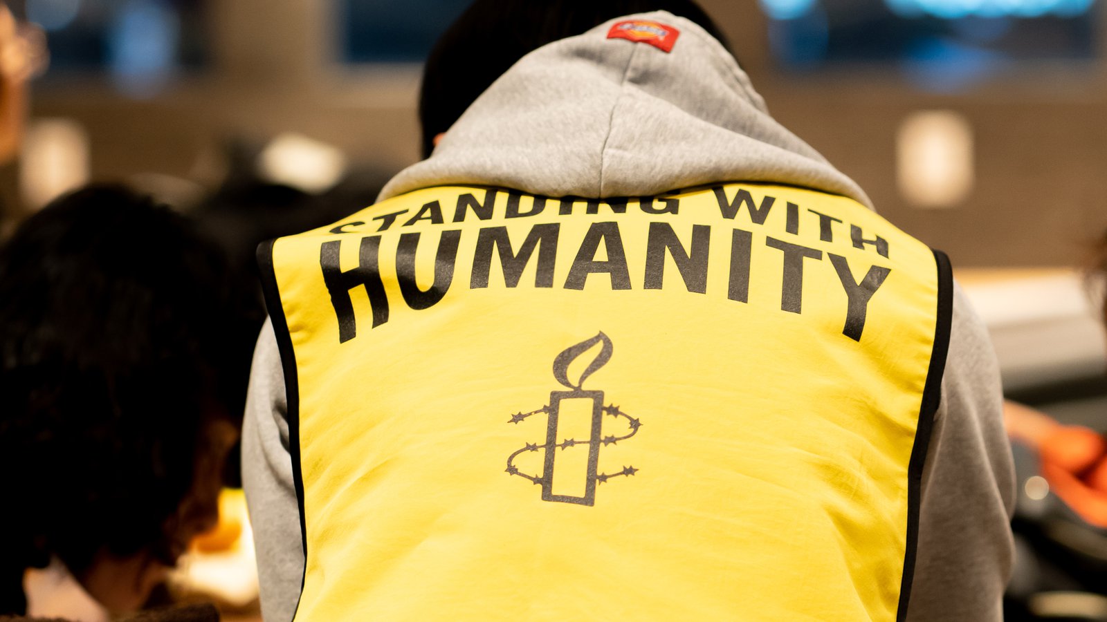 the back of a jacket saying 'standing with humanity'